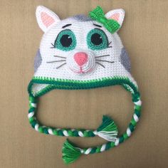 a crocheted hat with a cat's face on it and a green ribbon around the brim