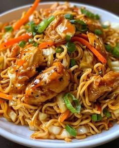 a white plate topped with noodles and chicken