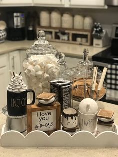 a tray filled with coffee and marshmallows on top of a kitchen counter