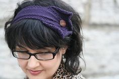 a close up of a person wearing glasses and a headband with a cell phone in her hand