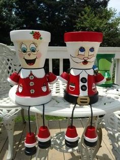 two christmas decorations sitting on top of a white table next to each other in the shape of santa and mrs claus