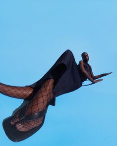 a woman in fishnet stockings and high heels flying through the air with her legs spread out