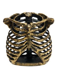 a gold and black skeleton ring with an open ribcage in the middle, on a white background