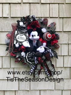 a mickey mouse wreath hanging on the side of a building