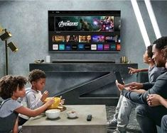 a group of people sitting around a table watching tv