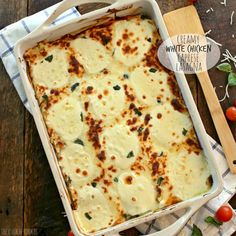 a casserole dish on a wooden table with tomatoes and parmesan cheese