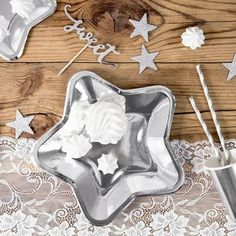 silver star shaped cake pans and cupcake cutters on a lace tablecloth