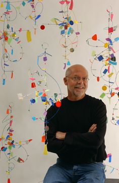 a man sitting in front of a colorful wall