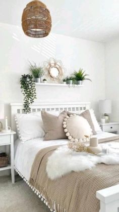 a bedroom with white walls and bedding, plants on the nightstands and a wicker basket hanging from the ceiling