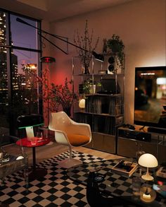 a living room filled with furniture and a flat screen tv mounted on a wall next to a window