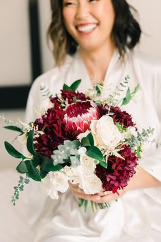 a woman holding a bouquet of flowers in her hands