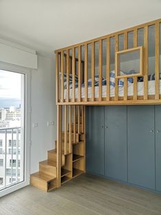 there is a bunk bed in the middle of this room with stairs to the second floor