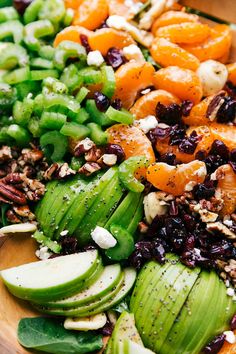 a wooden bowl filled with assorted fruits and vegetables