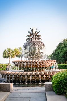 a fountain with pineapples on top and water cascading down the sides