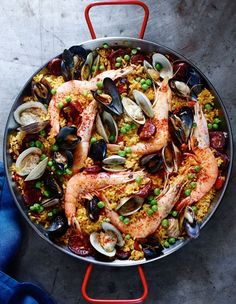 a pan filled with seafood and mussels on top of a table