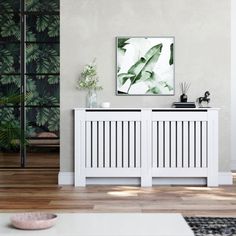 a living room with two white radiators in front of a painting on the wall