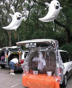 an outdoor event with balloons and decorations in the shape of ghost's