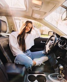 a woman sitting in the driver's seat of a car