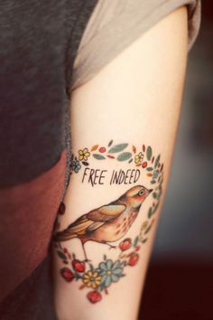 a woman's arm with a bird on it and the words free inked