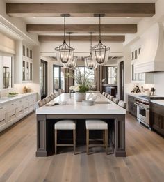 a large kitchen with wooden floors and white cabinets