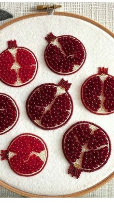 six pomegranates on a white surface with red thread in the middle