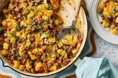 a pan filled with food next to two plates