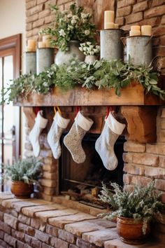 christmas stockings hung on the mantle with candles and greenery