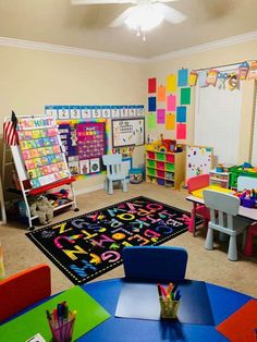 a classroom with lots of desks and colorful rugs on the floor in front of it