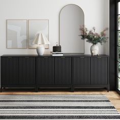 a black and white striped rug in front of a dresser with two vases on it