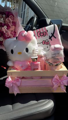 hello kitty in the back seat of a car with pink flowers and other items on it