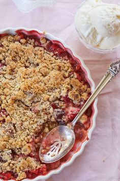 a pie with crumbs on top and a scoop of ice cream in the background