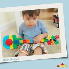 a young boy sitting on the floor playing with a toy