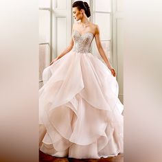 a woman in a wedding dress is standing by a window