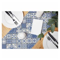 blue and white placemats with silverware on wooden table next to plated utensils