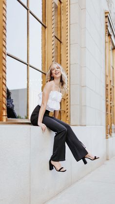 a woman sitting on the side of a building