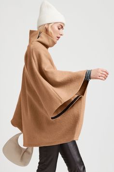 A stylish wool winter cloak, our Avery Cape is the ideal choice for heading out into the cold. Fashioned from Italian virgin wool and offered in fresh neutrals that pair well with any combination of clothing, this women’s wool cape is designed with a loose silhouette. Simple. Elegant. Cozy. Layer her over anything for an instant ready-to-go look. Avery's high collar has a side zipper for style and easy wear. This wool winter cape is lined for added warmth and comfort. | Maritza Chic Brown Wool Sweater Coat, Beige Merino Wool Sweater Coat For Fall, Fall Merino Wool Outerwear, Beige Cashmere Wool Coat For Winter, Modern Merino Wool Outerwear For Fall, Spring Beige Merino Wool Outerwear, Fall Merino Wool Outerwear With Funnel Neck, Brown Winter Cape For Cold Weather, Beige Cape For Winter Workwear