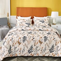 a bed with an orange headboard and white comforter in a yellow walled room