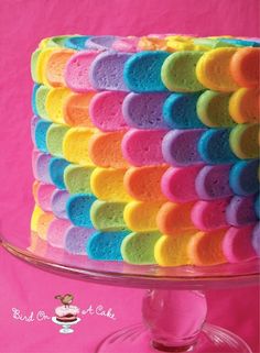 a colorful cake with lots of rainbow colored icing on it's side and the top layer is made out of marshmallows