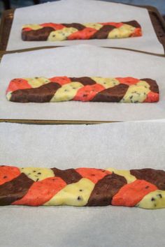 two trays with chocolate and orange treats on them sitting on top of parchment paper