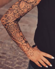 a woman's arm with tattoos on it, and her hand in the middle