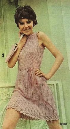 an old photo of a woman in a pink dress with her hands on her hips