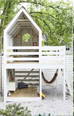 a white house with a hammock on the roof and stairs leading up to it