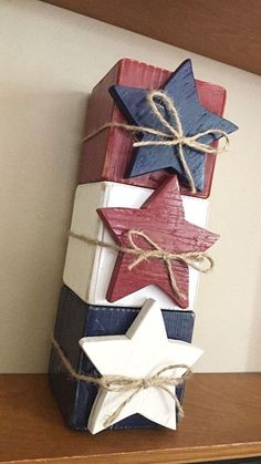 a stack of wooden blocks with stars tied to them on top of a shelf next to a wall