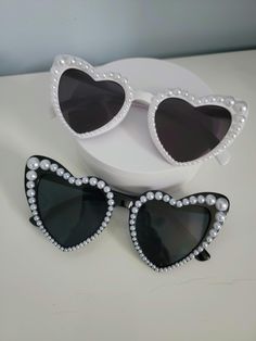 Get ready to turn heads and add some glamour to your look with these fabulous heart-shaped sunglasses with white pearl bling! These statement sunglasses are perfect for weddings, bridal accessories, sunny days, festivals or just adding a touch of glam to your outfit. The pretty pearls embellishing the frames add a touch of elegance and sophistication, making these shades a must-have accessory for any fashion-forward individual. Stand out from the crowd and sparkle in the sun with these stunning Statement Sunglasses, Shaped Sunglasses, Heart Shaped Sunglasses, The Pretty, White Pearl, Eyewear Sunglasses, Bridal Accessories, Pearl White, Fashion Statement