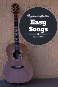 an acoustic guitar sitting against a wall with the words beginner guitar easy songs you can play