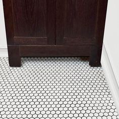 a bathroom floor with hexagonal tiles on the bottom and top, in black and white