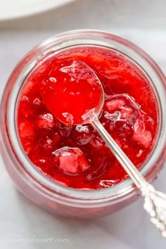 a spoon in a jar filled with jelly