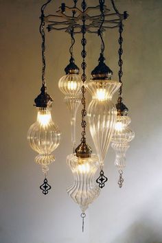 a chandelier with five lights hanging from it's sides in a room