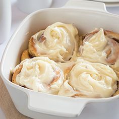 a white casserole dish filled with cinnamon rolls