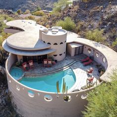 an aerial view of a house with a pool in the foreground and mountains in the background